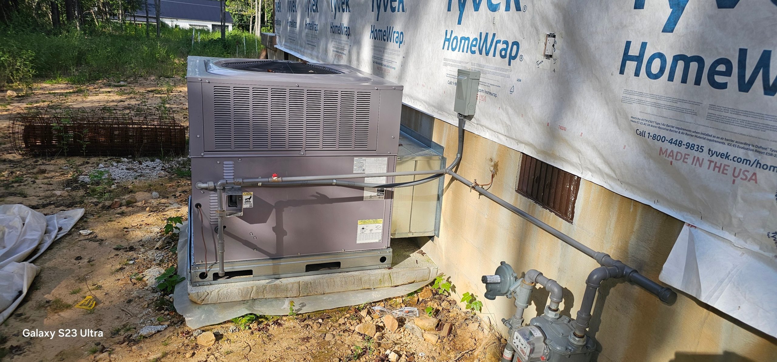 A new outdoor condenser is set beside house wrap and exterior service connections in Spencer, TN — Kilgore Heating and Air