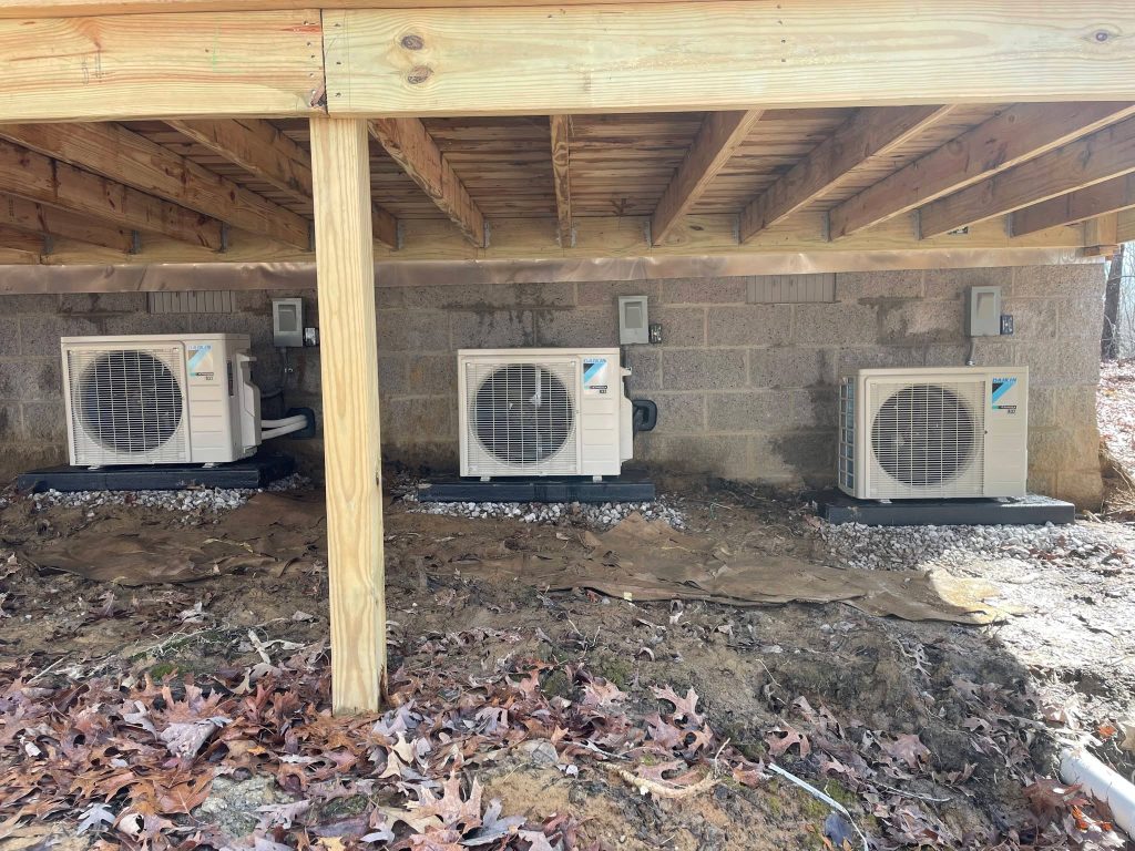 Three outdoor mini-split condensers beneath a home in the Sequatchie Valley