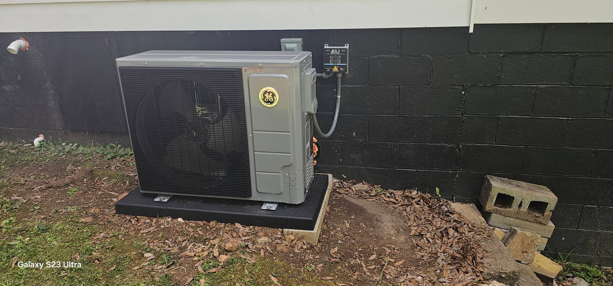 A new outdoor condenser sits on a level pad beside dark exterior siding in Pikeville, TN — Kilgore Heating and Air