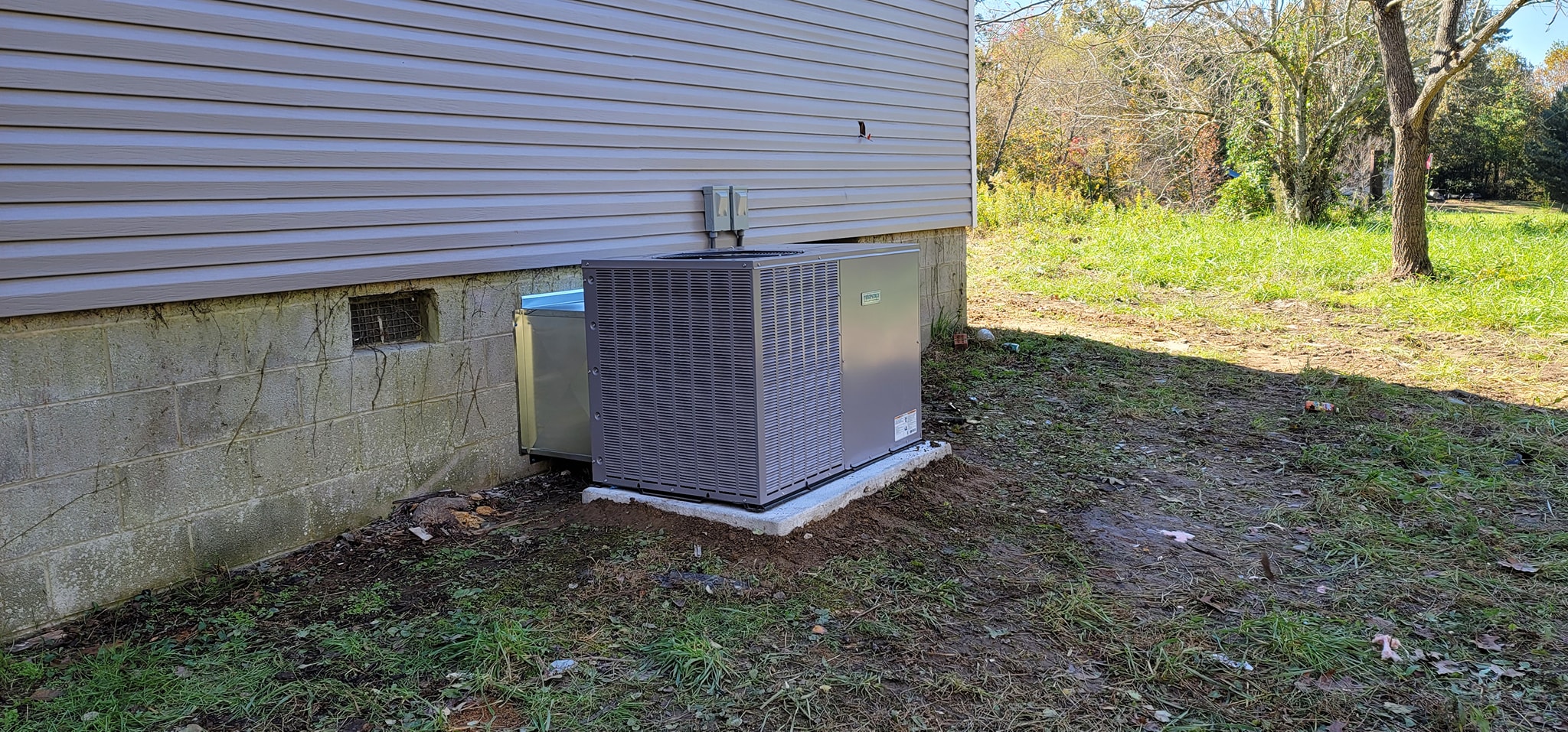 An outdoor condenser is installed on a pad along the side of a house in Chattanooga, TN — Kilgore Heating and Air