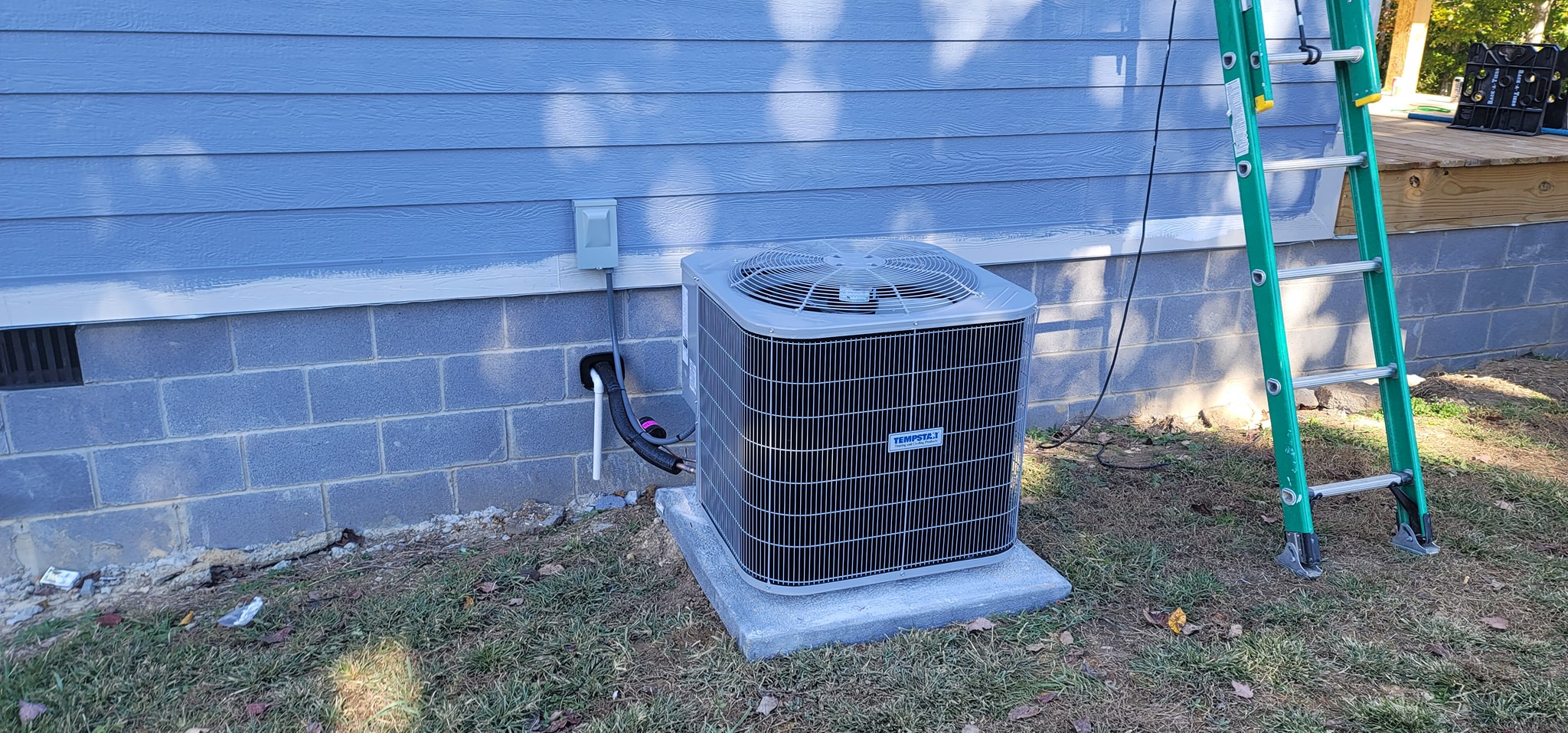 An outdoor condenser is installed beside a home's exterior wall with a ladder nearby in Soddy-Daisy, TN — Kilgore Heating and Air