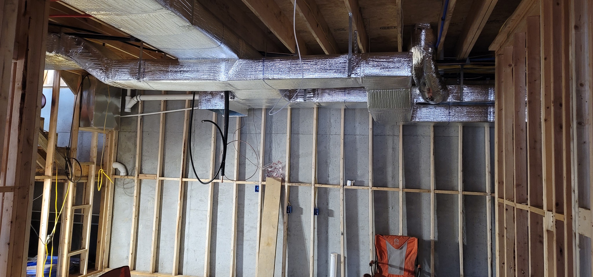 Reflective insulated supply trunk and branch ducts run below open floor framing — diagnosing a furnace blowing cold air