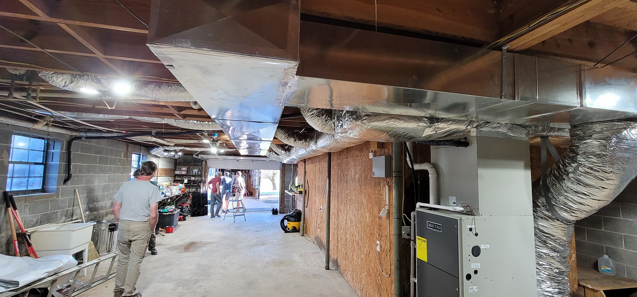A furnace connects to custom metal ductwork and insulated branches in a basement — diagnosing spiked HVAC utility bills