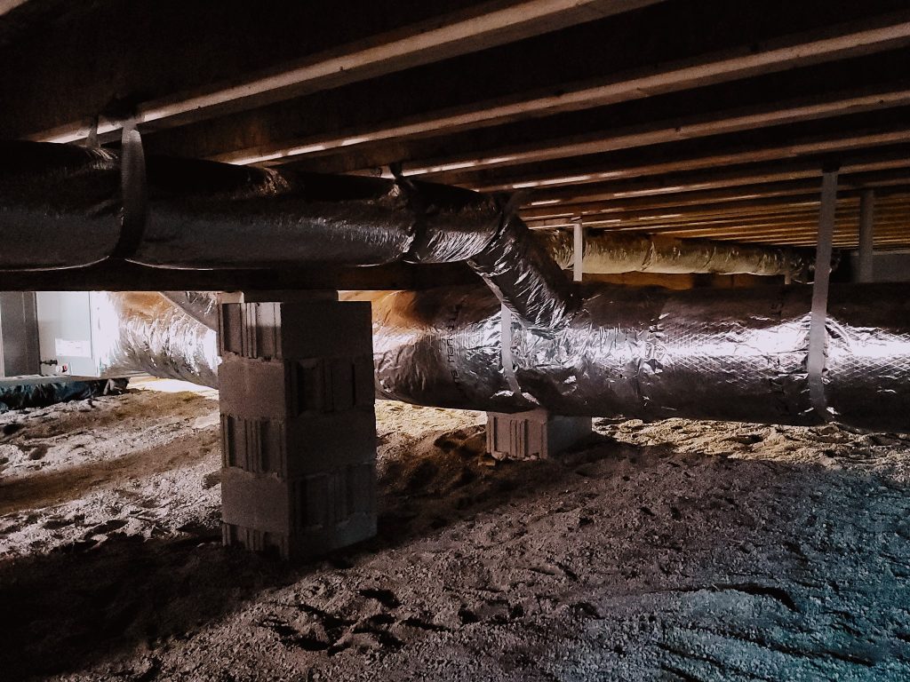 Reflective ductwork routed through dirt-floor crawlspace project photo