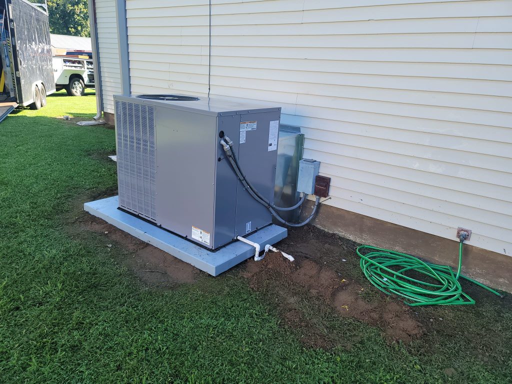 New outdoor package unit installed beside a home
