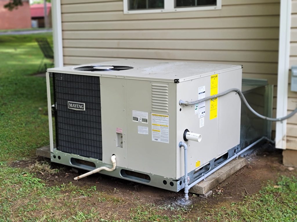 Packaged HVAC unit installed beside exterior siding