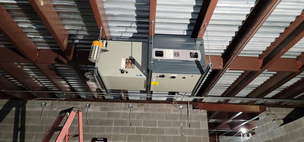 Commercial HVAC unit installed under metal building roof