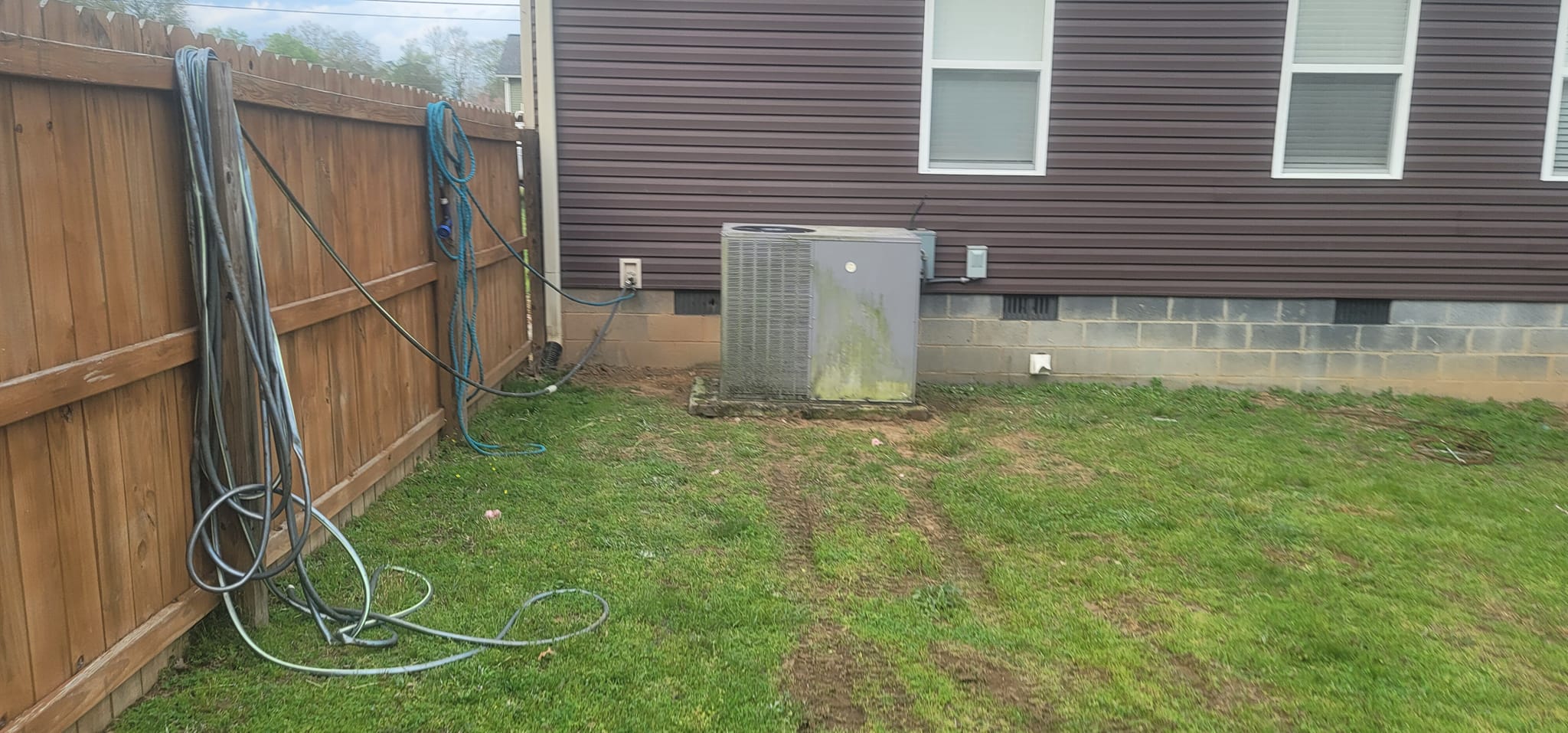 Two outdoor condensers sit beside a brown-sided home with service lines at the wall in Gruetli-Laager, TN — Kilgore Heating and Air