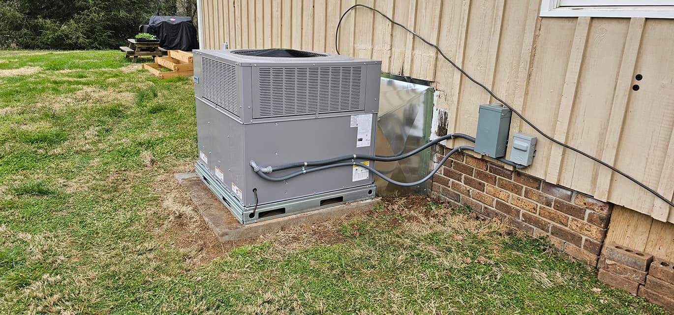 A residential package unit sits on a pad beside a wood-sided home in Bridgeport, AL — Kilgore Heating and Air