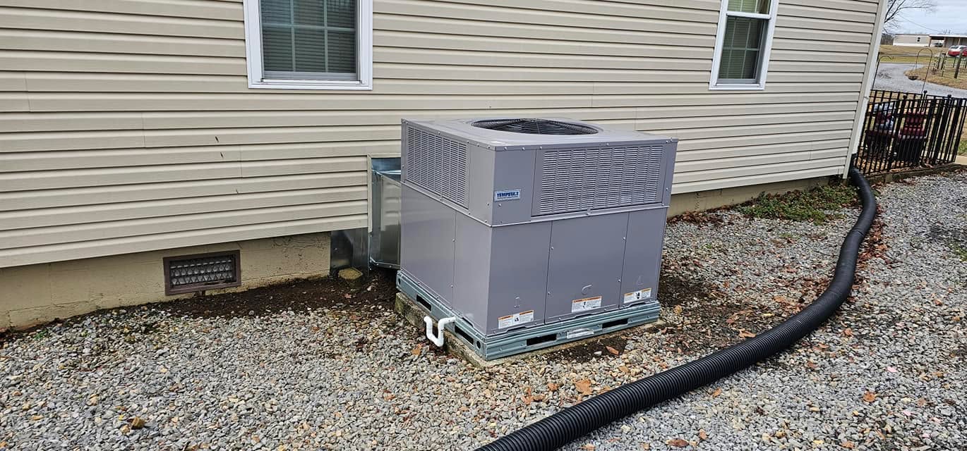 A new outdoor condenser sits on a pad beside a light-sided home in Coalmont, TN — Kilgore Heating and Air